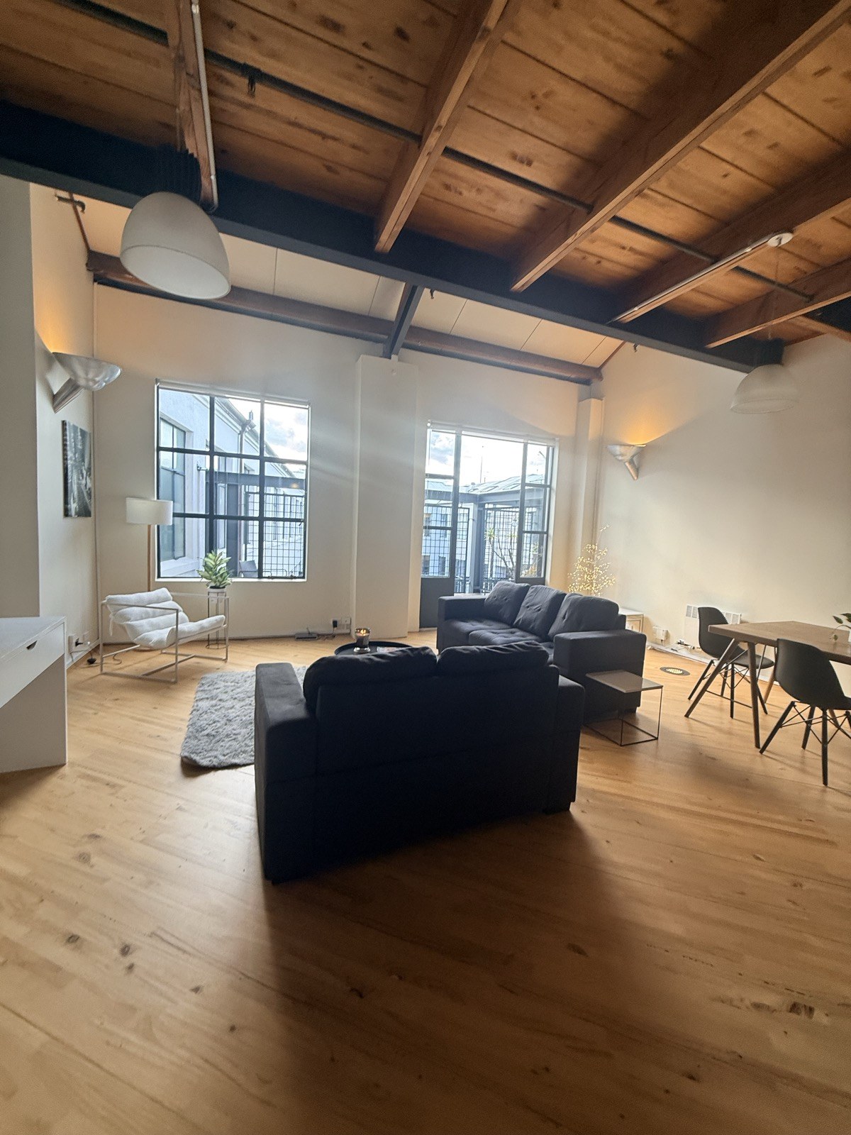 The open living and dining space with charcoal sofas and tall windows