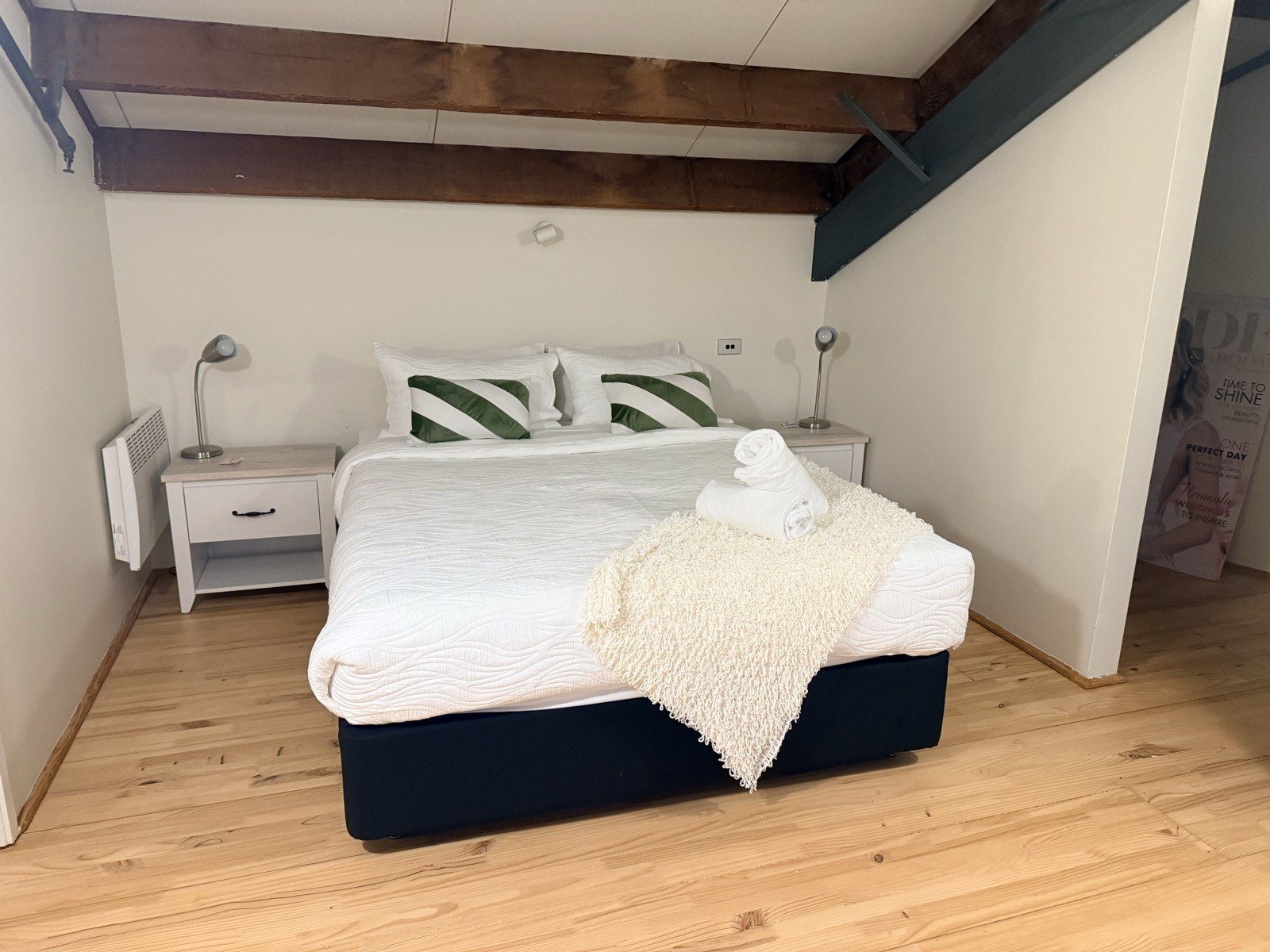 The bedroom with timber beams and crisp white linen