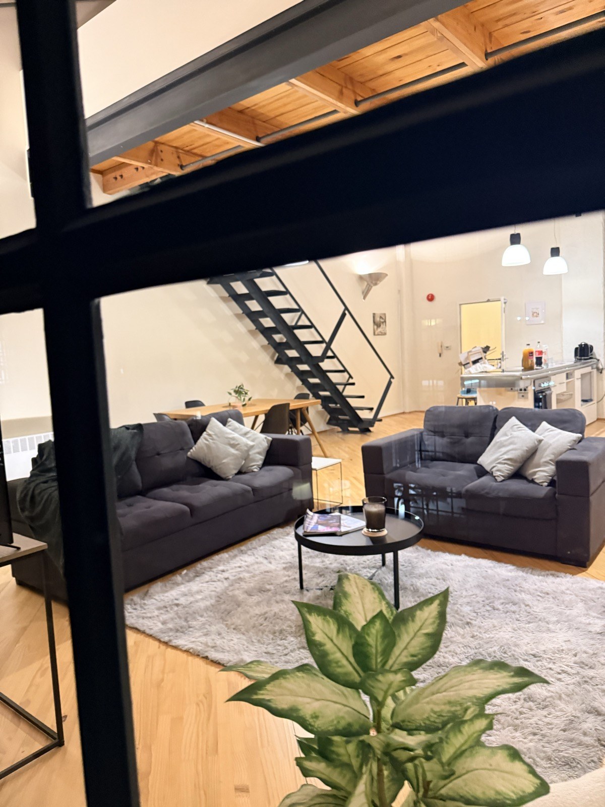 The black steel staircase and the living area seen from the mezzanine