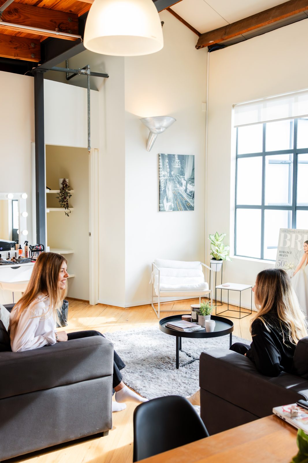 The open living area with charcoal sofas and tall black-framed windows