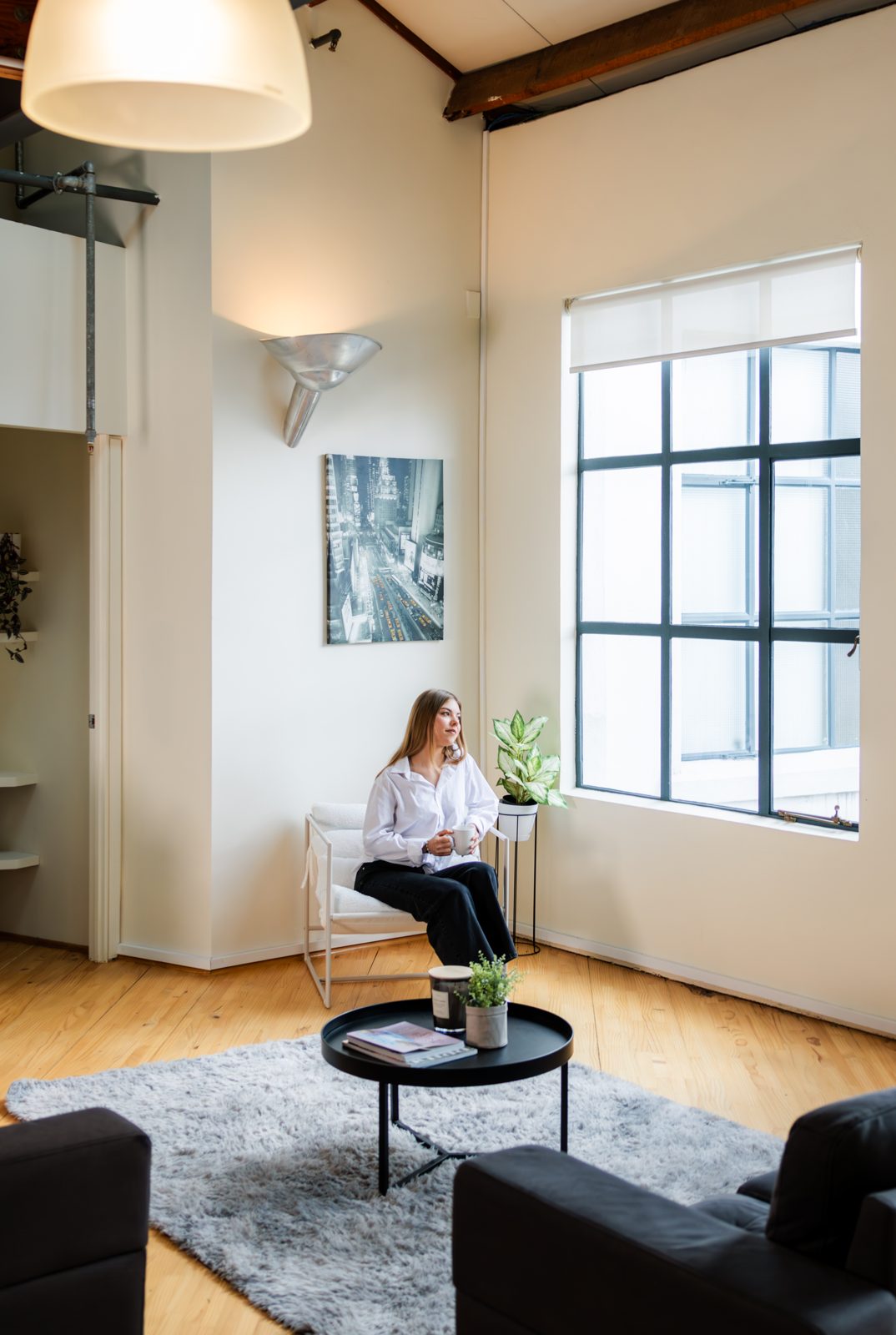 A quiet seating corner with a round table and tall windows
