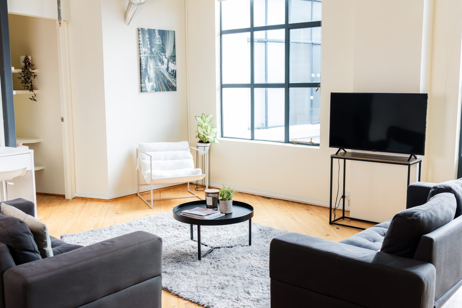 The living space with sofas, rug and tall windows