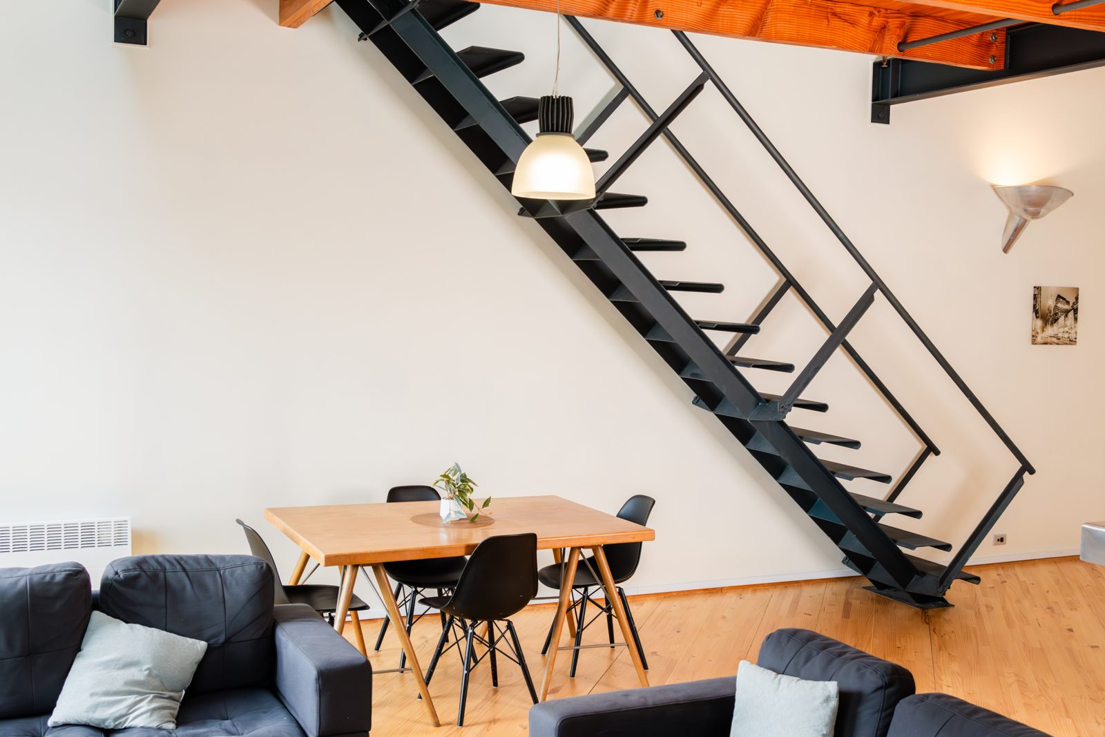 The black steel staircase, dining and living areas of the loft